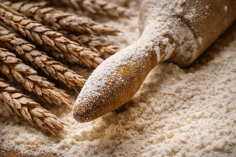 Harina y granos en una superficie clara, ingredientes básicos